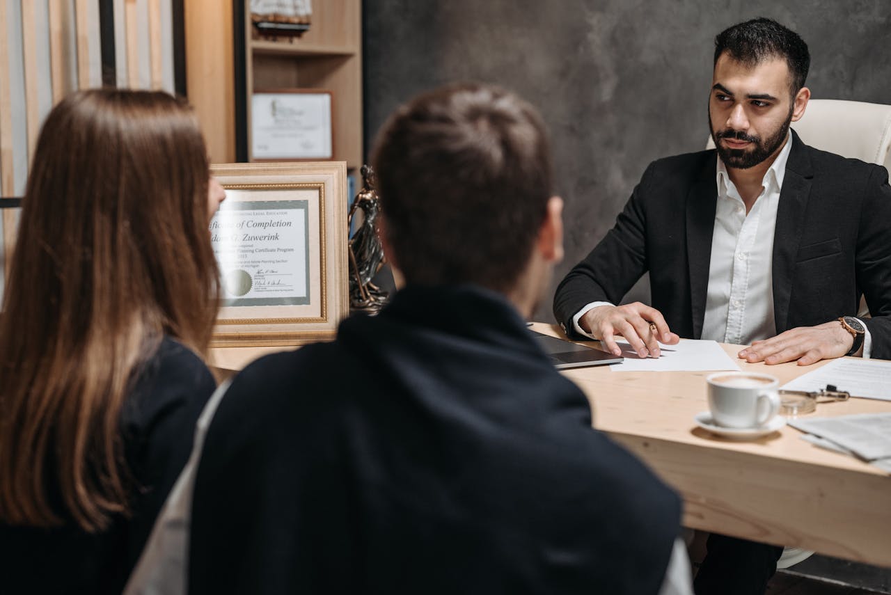 A lawyer in an elegant office meeting with clients, discussing documents.